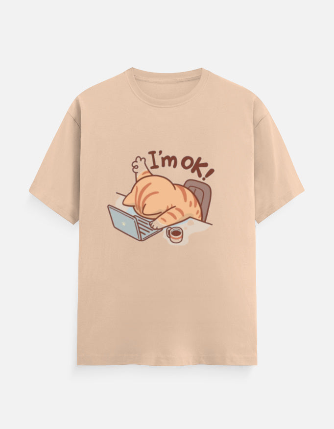 Unisex beige classic crew t-shirt with 'I'm OK!' cat graphic lying on a laptop.
