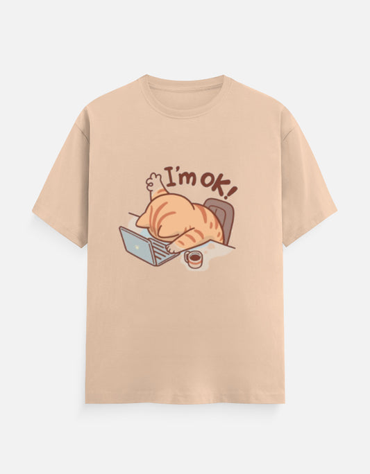 Unisex beige classic crew t-shirt with 'I'm OK!' cat graphic lying on a laptop.